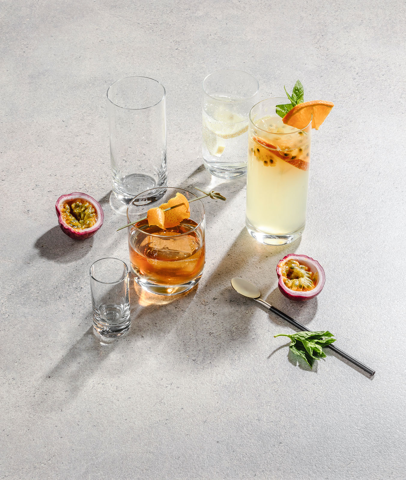 Draufsicht auf einige Gläser der Serie Simple von Schott Zwiesel, angerichtet mit Cocktails. Zutaten liegen verstreut um die Gläser.