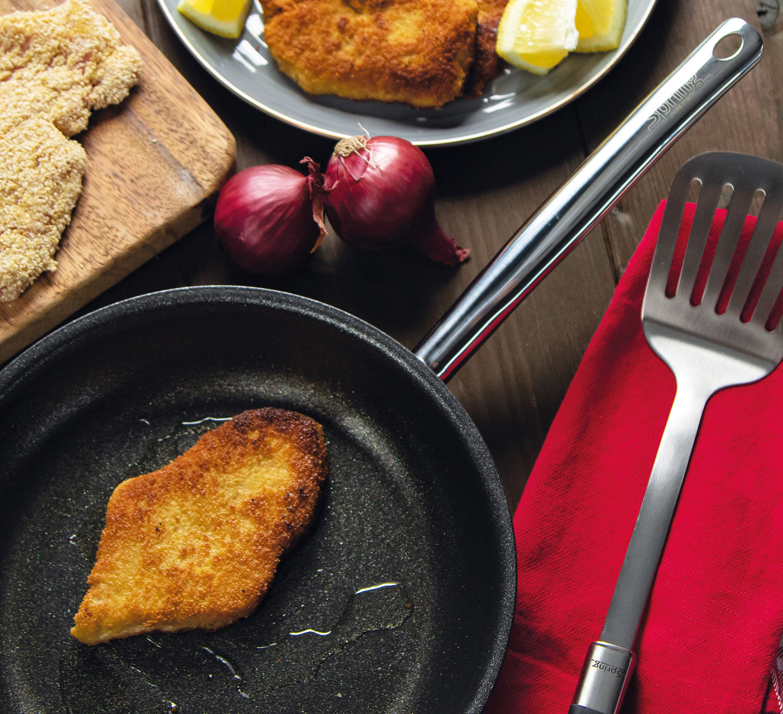 Draufsicht auf eine Vulcano Intense Pro Bratpfanne, in der ein frisch gebratenes Schnitzel liegt.