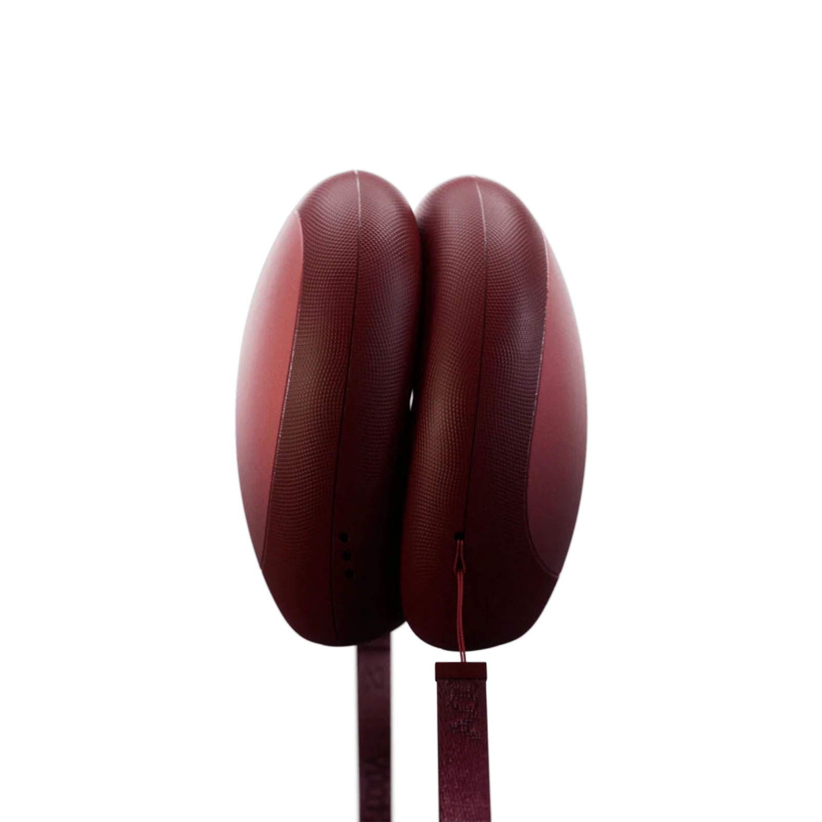 Die Stoons Handwärmer von Stoov sind zwei halbrunde Formen in einem dunklen Rot. An ihnen befestigt sind rote Gurte für die Handgelenke.