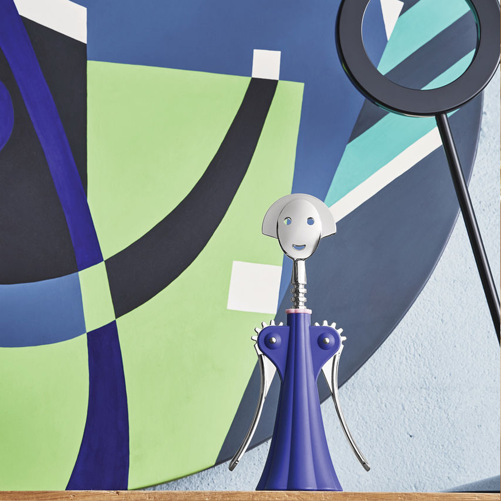 Alessi Anna G. Korkenzieher in dunkelblau von Alessandro Mendini auf einem gedeckten Tisch.