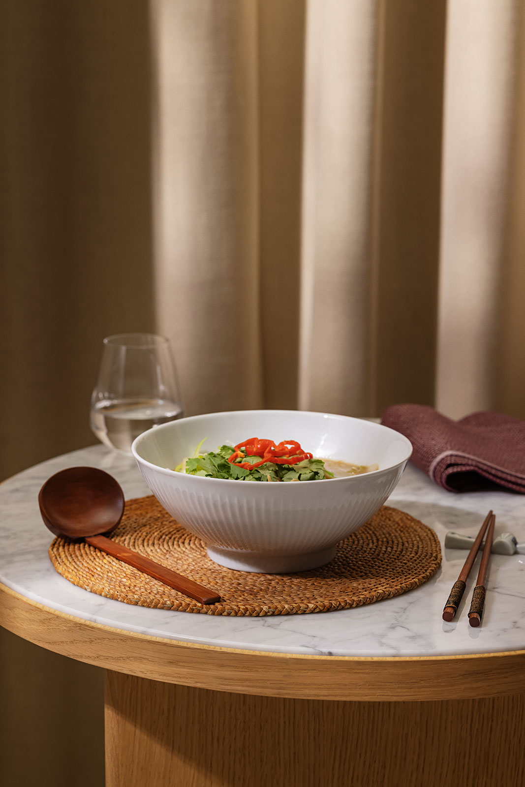 Auf einem runden Tisch sind in der Legio Nova Schale von Eva Trio leckere Ramen-Nudeln angerichtet.