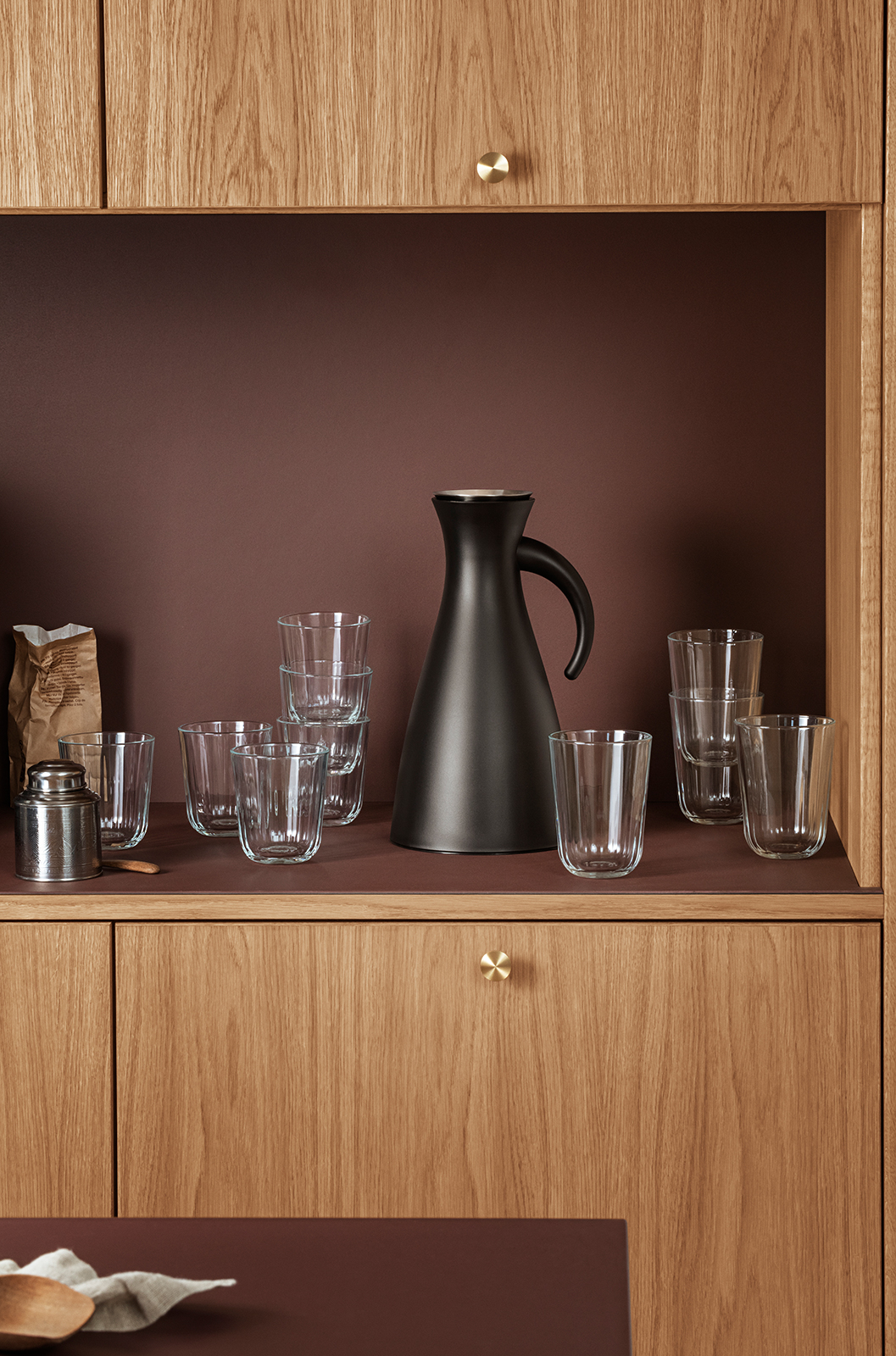 Eine Küchenzeile aus Holz mit Eva Trio Trinkgläsern und weiteren Utensilien.