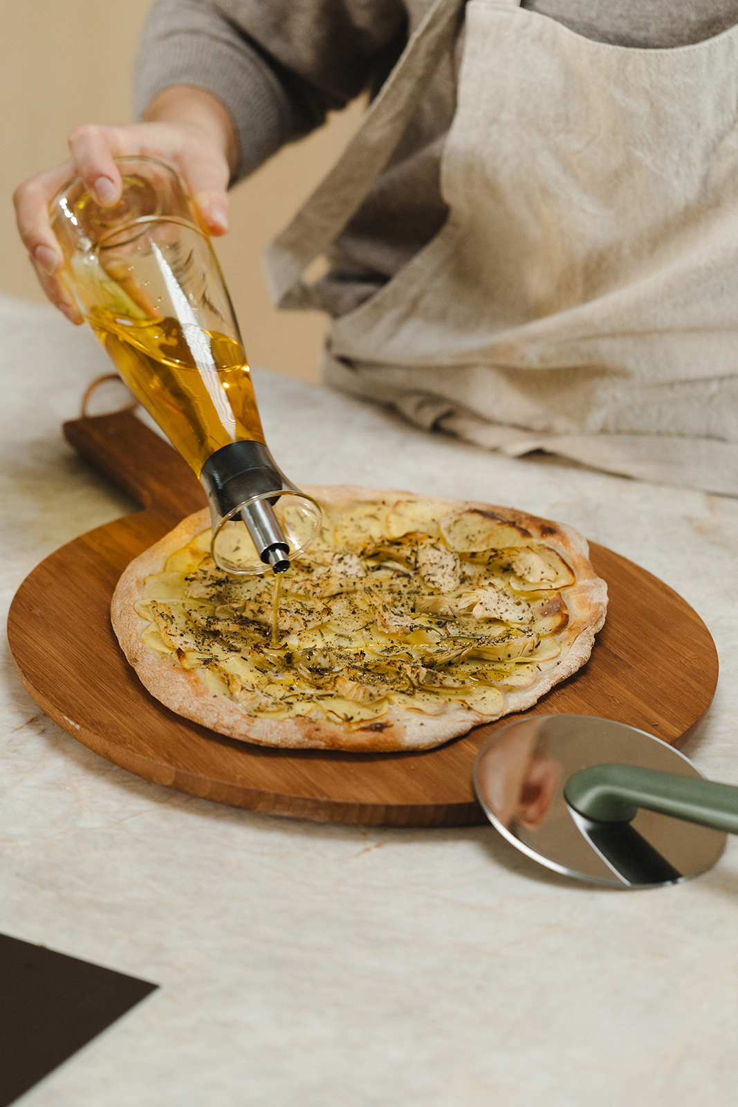 Ein bisschen selbstgemachtes Öl über die selbstgemachte Pizza geben. Fertig ist das Leibgericht.