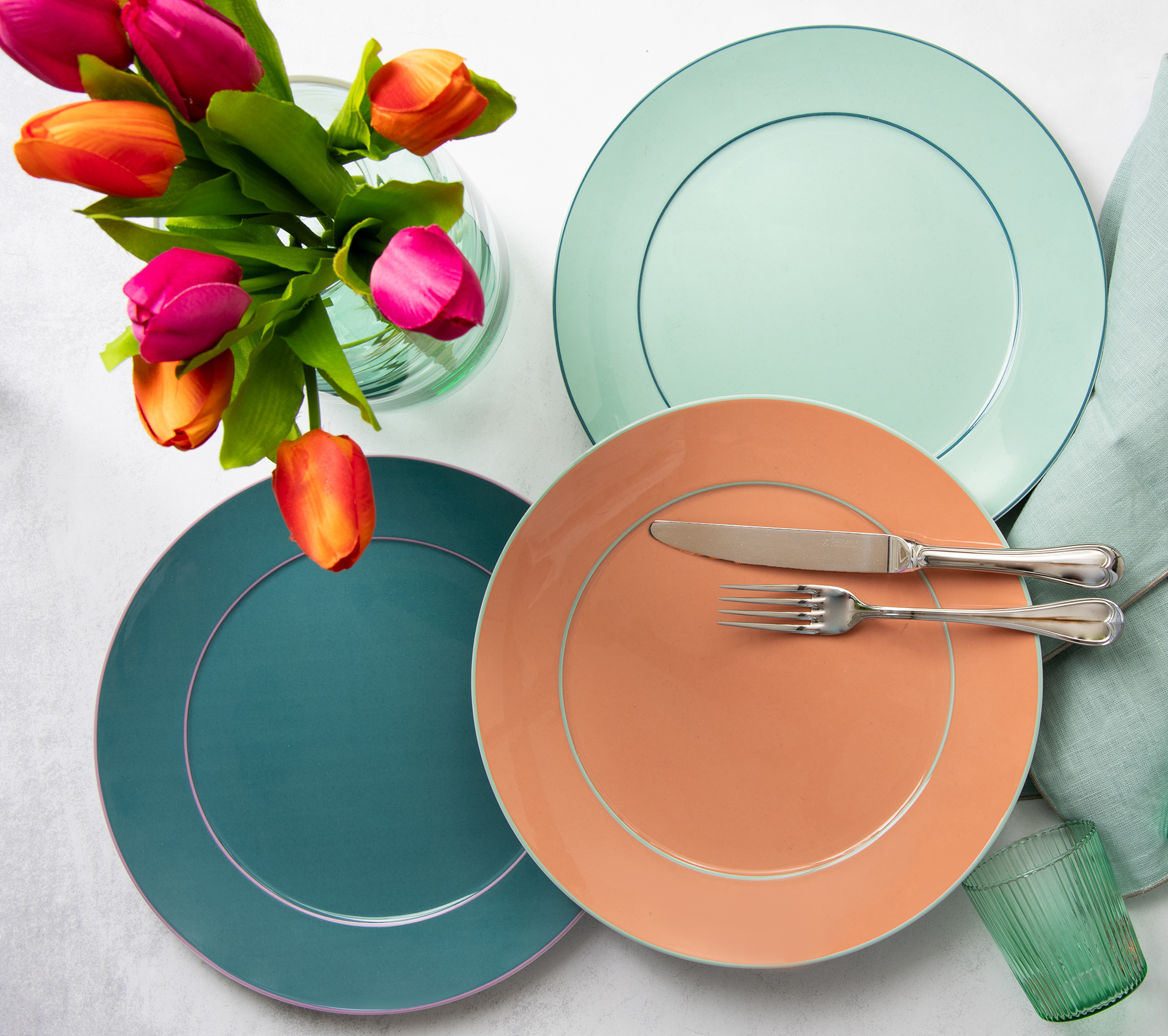 Verschieden farbige Meissen Urban Colors Teller als Stimmungsbild zusammen mit anderen Tischaccessoires auf einem Tisch dekoriert.
